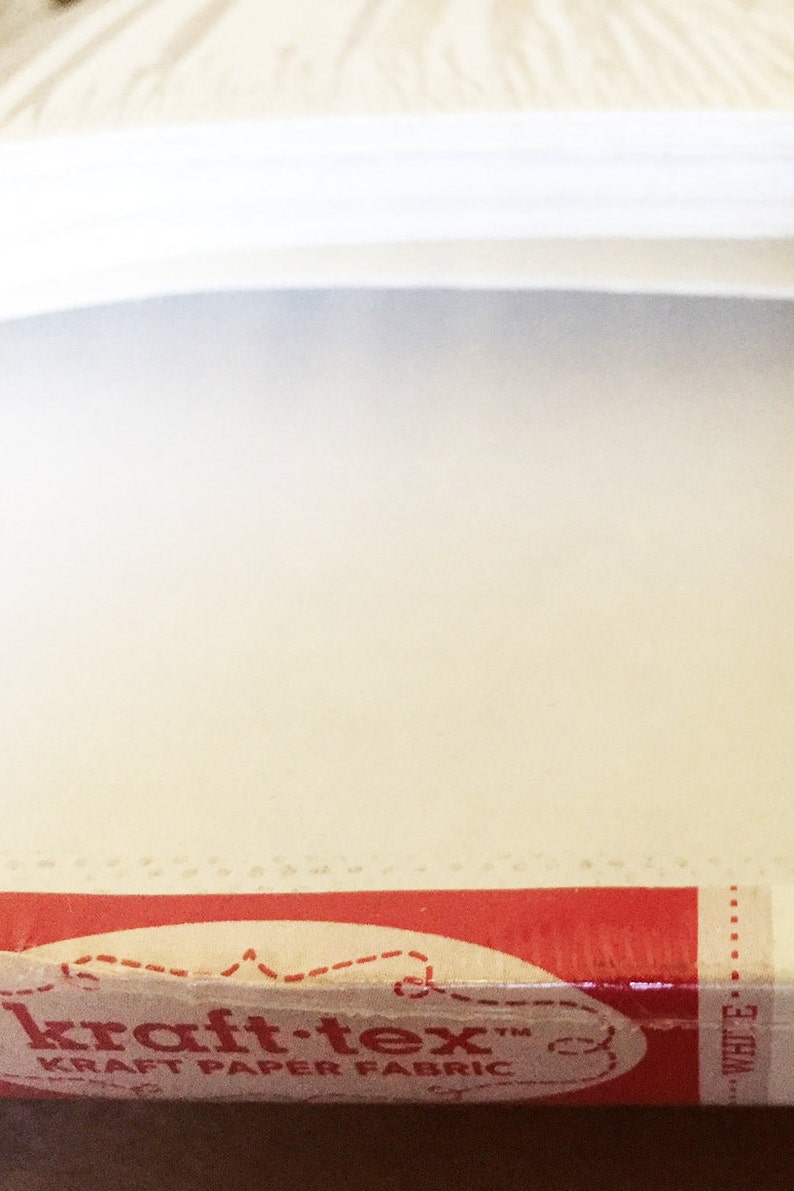 May include: Close-up of a red and white box with the text "kraft-tex" and "KRAFT PAPER FABRIC" printed on it.