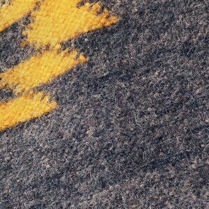May include: Close-up of a gray fuzzy fabric with a yellow stripe pattern.