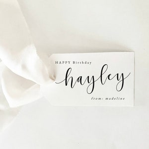 May include: White gift tag with black calligraphy that reads "Happy Birthday Hayley from: Madeline".