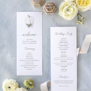 May include: A wedding ceremony program with a white pumpkin illustration and calligraphy text. The program includes the wedding party, ceremony details, and a thank you message from the couple. The text reads "Welcome to the wedding of Melanie & Andrew, San Diego, CA September 21, 2020".