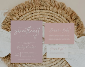 May include: A pink baby shower invitation with white text. The invitation reads "A little sweetheart is on the way!" and includes the name "Kagley Madison". There are also two smaller cards, one for a diaper raffle and one for a book request.