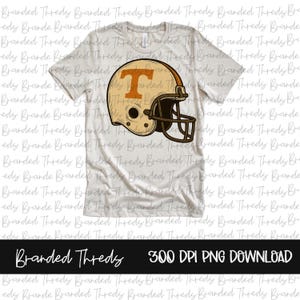 Puede incluir: Camiseta blanca con un dise&ntilde;o de casco de f&uacute;tbol americano vintage. El casco es de color beige y marr&oacute;n con una "T" naranja. El texto "Branded Threds" y "300 DPI PNG DOWNLOAD" est&aacute;n en la parte inferior.