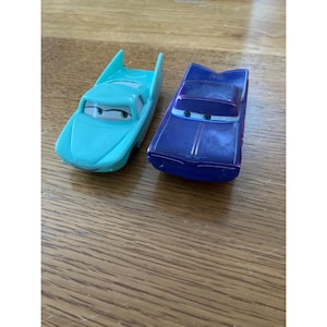 Puede incluir: Una taza de cerámica blanca con un asa negra y el texto "But First, Coffee" en negrita negra. La taza se encuentra sobre un fondo neutro, resaltando su diseño sencillo.