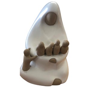 May include: A smooth, white ceramic sculpture depicting a large central figure with a rounded head and a draped form, surrounded by five smaller, tan-colored figures. One small figure stands to the side, while four others are clustered together.