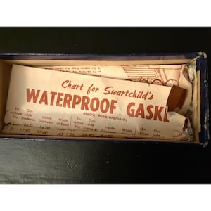 May include: A vintage blue box containing a chart for Swartchild's Waterproof Gaskets. The chart, printed on aged paper, displays metric measurements for various gasket sizes, including inside and outside diameters.