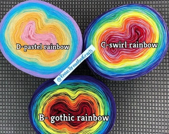 May include: Three skeins of yarn in different rainbow colorways. The skeins are labeled "D-pastel rainbow", "C-swirl rainbow", and "B-gothic rainbow".