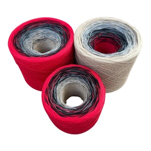 May include: Three skeins of yarn in a gradient color scheme. The yarn colors include red, black, gray, and beige. The yarn is tightly wound into a cone shape, with a hole in the center. The yarn is likely used for knitting or crocheting projects.