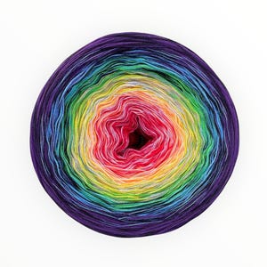 May include: A skein of rainbow colored yarn wound into a ball. The yarn is a gradient of colors, starting with purple and ending with yellow.