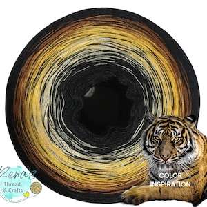 May include: A skein of yarn with a black, brown, gold, and white color gradient. The yarn is wound into a circle and the center is visible. The yarn is inspired by a tiger, with the text "COLOR INSPIRATION" below the image of a tiger.