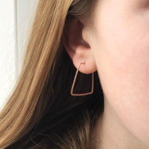Peut inclure: Une paire de boucles d'oreilles créoles triangulaires en or rose. Les boucles d'oreilles sont simples et délicates, et elles feraient un excellent cadeau pour un ami ou un être cher.