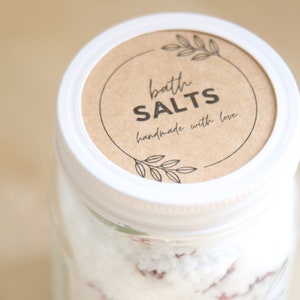 May include: A white jar with a brown label that reads "bath salts handmade with love".