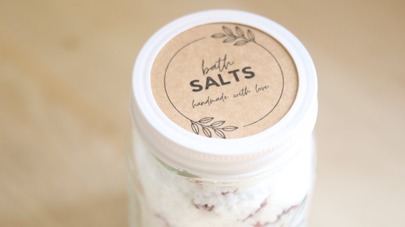 May include: A white jar with a brown label that reads "bath salts handmade with love".