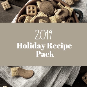 May include: A brown bowl filled with a snack mix of pretzels, cereal squares, and chocolate pieces. The bowl is sitting on a white linen napkin. The text "2019 Holiday Recipe Pack" is displayed on a brown background.