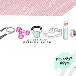 May include: A personalized notepad with a light green watercolor background and the text "Personalized Notepad". The notepad features a line of fitness-themed illustrations: a jump rope, pink dumbbells, a green kettlebell, white sneakers, a clear water bottle, and a pink fitness tracker.