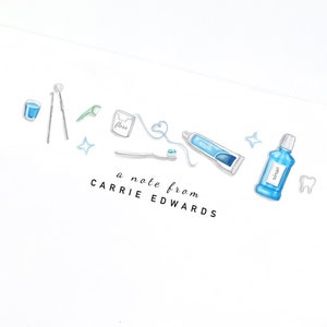 May include: White notepad with illustrations of dental hygiene tools, including a toothbrush, toothpaste, floss, and mouthwash. The text "a note from CARRIE EDWARDS" is printed below the illustrations. A pen is visible in the bottom right corner.