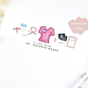 May include: A personalized notepad with a pink scrubs top, stethoscope, medical supplies, and the text "a note from DR. KATHRYN MOORE".