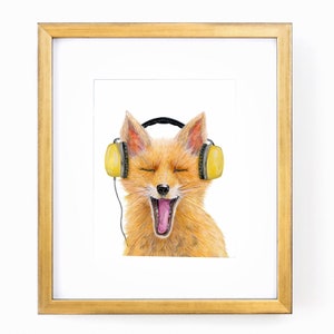 May include: A framed art print featuring a watercolor illustration of a fox wearing yellow headphones. The fox has its eyes closed and mouth open, as if singing or yawning. The frame is gold.