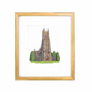 May include: A framed illustration of a tall, stone church with a pointed spire. The church is surrounded by green trees and grass. The frame is gold.
