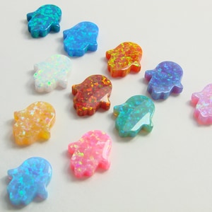 May include: Assortment of colorful opal hamsa hand charms. The charms are in various colors, including blue, green, orange, red, pink, and white.