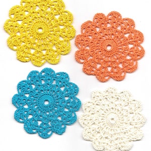Puede incluir: Cuatro doilies de ganchillo en amarillo, naranja, azul y blanco.