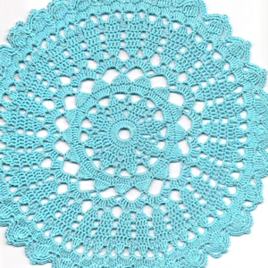 May include: A light blue crocheted doily with a delicate floral pattern.