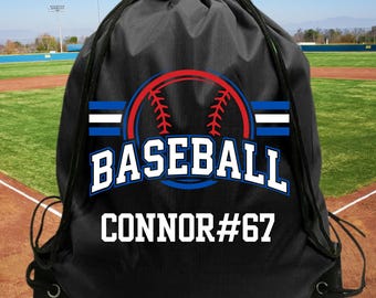 May include: A black drawstring backpack featuring a graphic of a red baseball with blue and white stripes. The word BASEBALL is printed in large blue letters, and the name CONNOR#67 is printed in white text at the bottom of the bag.
