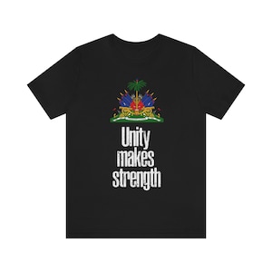 May include: Black t-shirt with the coat of arms of Haiti and the text "Unity makes strength" in white.