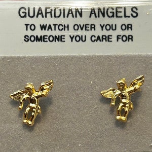 Pode incluir: Um par de brincos de anjo da guarda em tom dourado. Os brincos apresentam um pequeno anjo com as asas abertas. O cart&atilde;o diz "Guardian Angels To Watch Over You Or Someone You Care For".