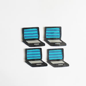 Peut inclure: Quatre découpes de laptop noires avec des écrans rayés bleus et blancs. Les découpes sont disposées en carré sur un fond blanc.