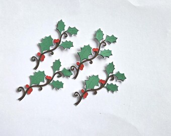 May include: Four die-cut paper holly sprigs featuring dark brown curved stems, serrated green leaves, and small bright red berries. Each sprig is arranged in a cluster, showcasing a flat, two-dimensional design with clean white edges.