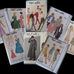 May include: A collection of vintage McCall's sewing patterns featuring illustrations of dresses, coats, and other garments. The patterns are from various eras, including the 1970s and 1990s, with a variety of styles and designs.