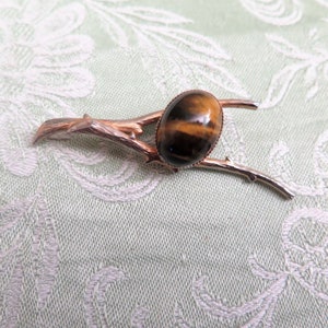 Spilla vintage color oro con un autentico cabochon in occhio di tigre, anni '70 circa