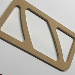 May include: A light brown wooden template with three cut-out shapes. The shapes are all different sizes and have curved edges.