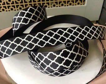 May include: Black and white patterned ribbon with a geometric design. The ribbon is made of a soft, silky material.