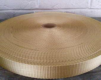 May include: A roll of beige nylon webbing, a type of strong, durable fabric often used for straps, belts, and other applications.