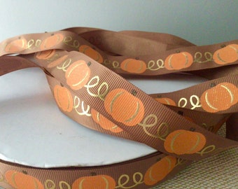 May include: Brown ribbon with a repeating pattern of orange pumpkins and gold swirls.