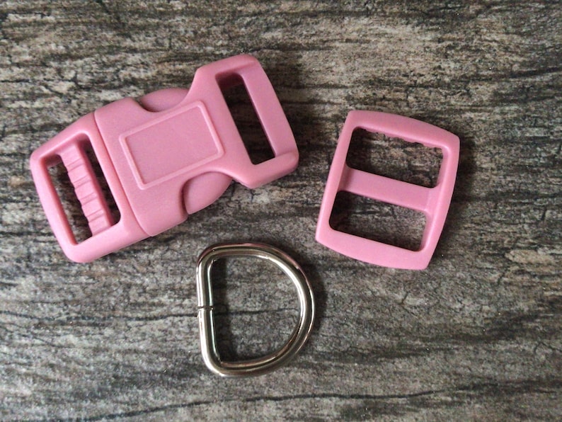 May include: Pink plastic buckle, slider, and D-ring for a dog collar or leash.