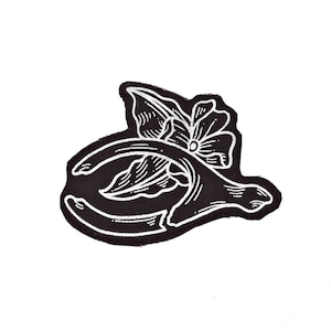 May include: Black and white embroidered patch of a horseshoe with a flower design.