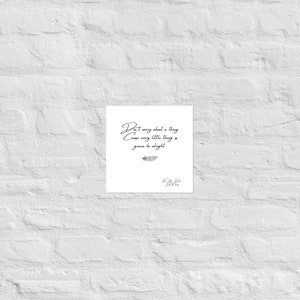 May include: A white square print with the quote "Don't worry about a thing cause every little thing is gonna be alright" in elegant black script. A small feather illustration is below the quote, with the artist's signature at the bottom.