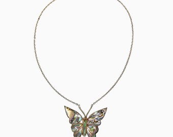 May include: A silver chain necklace with a butterfly pendant made of iridescent abalone shell.