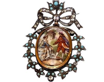 May include: An antique brooch with an oval-shaped painted scene of two figures in a garden. The brooch features a silver-tone bow, turquoise-colored beads, and clear crystals. The brooch is an elegant piece of jewelry.