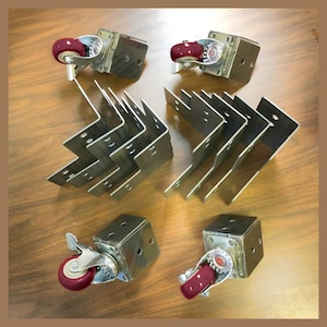 May include: A set of 10 metal corner brackets and 4 swivel casters with red wheels. The casters are designed to be mounted on furniture.