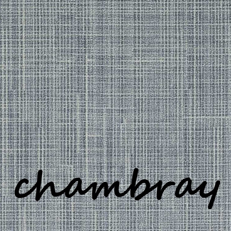 May include: Close-up of a textured chambray fabric in shades of blue and white. The word "chambray" is written in a cursive font across the bottom of the image. The fabric has a woven appearance.