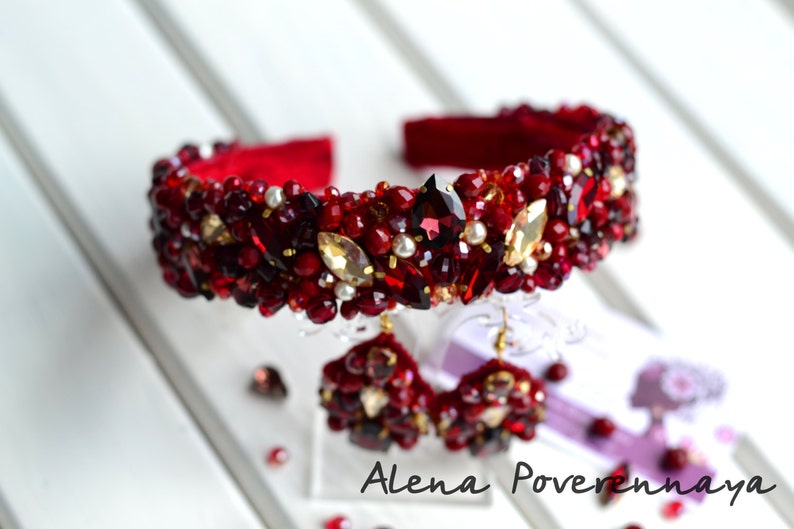 May include: A red headband and matching earrings with red and gold beads and rhinestones.