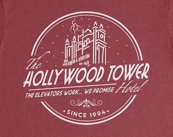 Könnte beinhalten: Rotes T-Shirt mit einer weißen Grafik eines Gebäudes mit dem Text "The Hollywood Tower Hotel. The elevators work... we promise. Since 1994."