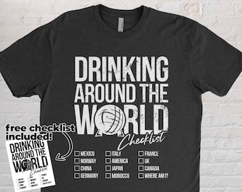 Könnte beinhalten: Ein dunkelgraues T-Shirt mit dem Text "Drinking Around the World Checklist" in Weiß. Das Shirt zeigt eine Grafik eines Globus und eine Checkliste von Ländern, in denen man trinken kann.