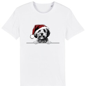 Puede incluir: Camiseta blanca con una ilustración en blanco y negro de un perro con un gorro de Papá Noel rojo. El perro mira por encima de una línea negra. La camiseta tiene cuello redondo y es de material suave.
