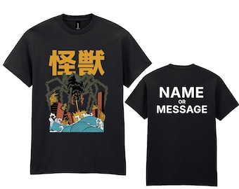 May include: Black t-shirt featuring a Japanese-style illustration of a giant spider destroying a city, with the Japanese characters for "monster" above. The back of the shirt has the text "NAME OR MESSAGE" in white.