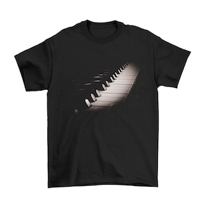 May include: Black t-shirt featuring a graphic of a piano keyboard in black and white.