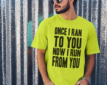 May include: A neon green t-shirt with black text that reads "Once I ran to you now I run from you".